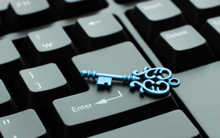 Close-up of a computer keyboard with a sky-blue antique key on top of the Enter key